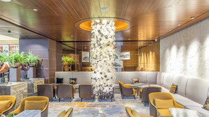 A modern interior with a central column, seating areas, and a reception desk. - Crowne Plaza Beijing Chaoyang U-Town by IHG (Beijing)