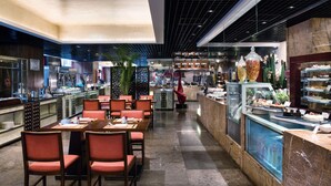 A modern restaurant with a central dining area, a counter with a display case, and a variety of food items. - Crowne Plaza Beijing Chaoyang U-Town by IHG (Beijing)