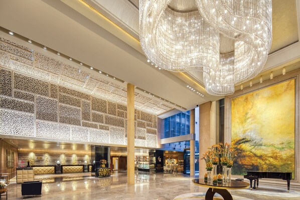 A spacious lobby with a grand chandelier, a reception desk, and a large painting on the wall. - Crowne Plaza Beijing Chaoyang U-Town by IHG (Beijing)