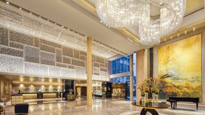 A spacious lobby with a grand chandelier, a reception area, and a large painting. - Crowne Plaza Beijing Chaoyang U-Town by IHG (Beijing)
