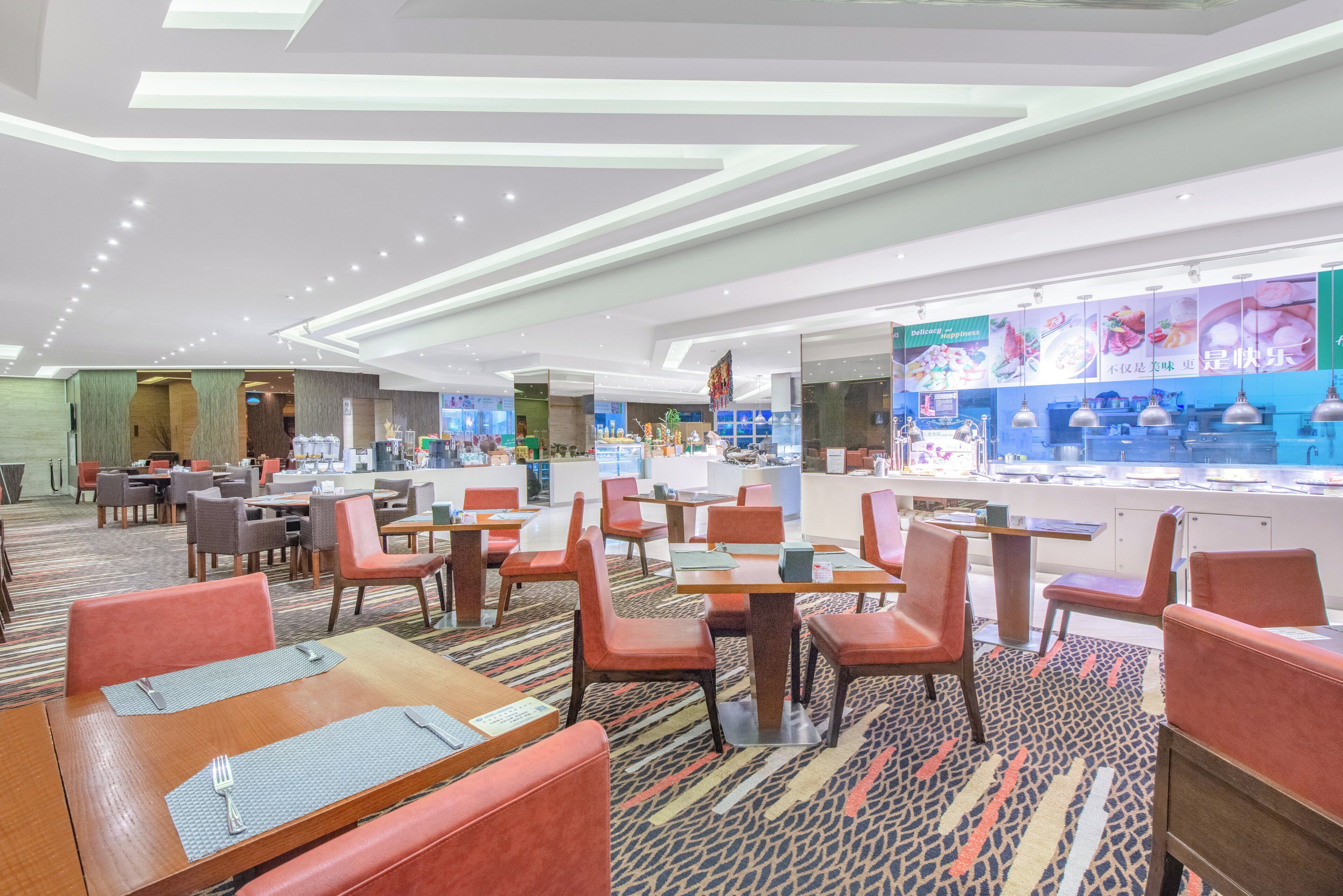 Een modern restaurant met verschillende eetgedeeltes, waaronder zitjes en tafels, en een balie voor het bestellen.