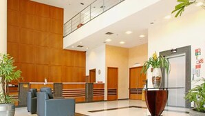 A modern lobby with a reception desk, seating area, and a staircase. - Travel Inn Hotels Ibirapuera (São Paulo)