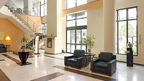 A spacious lobby with a staircase, seating area, and large windows. - Travel Inn Hotels Ibirapuera (São Paulo)