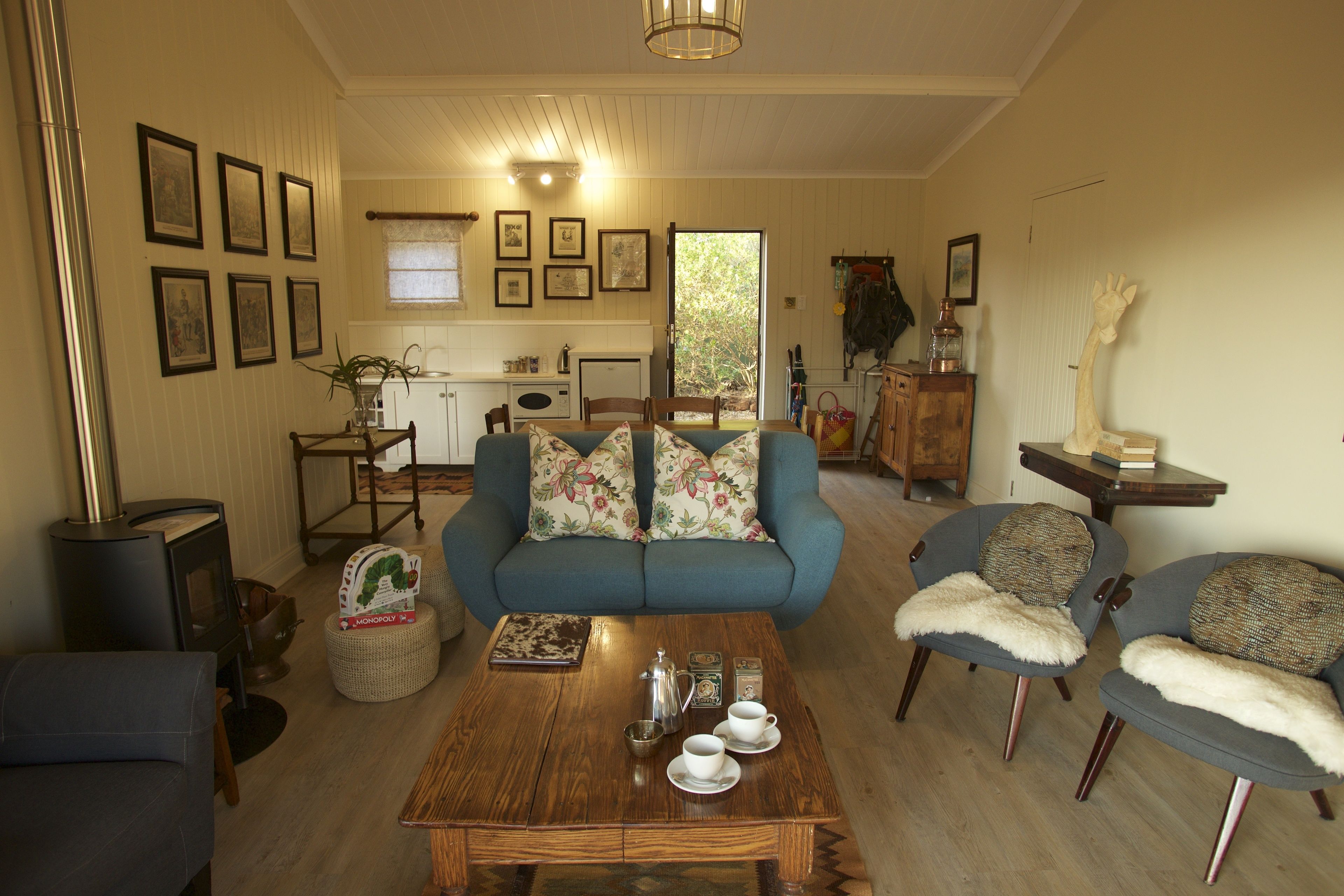 Een gezellige woonkamer met een bank, fauteuils, een salontafel en een open haard.