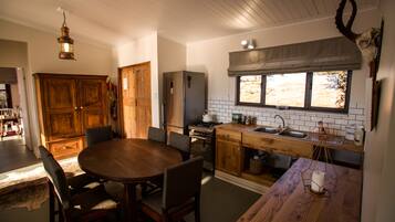 A kitchen with wooden cabinets, a dining table, and a window with a view.