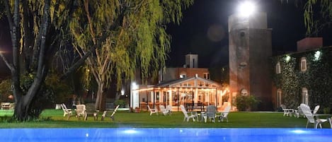 Een seizoensgebonden buitenzwembad en ligstoelen