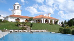 A large swimming pool with a white building in the background.