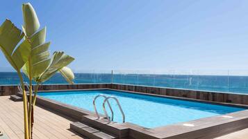 Piscine extérieure, parasols de plage, chaises longues