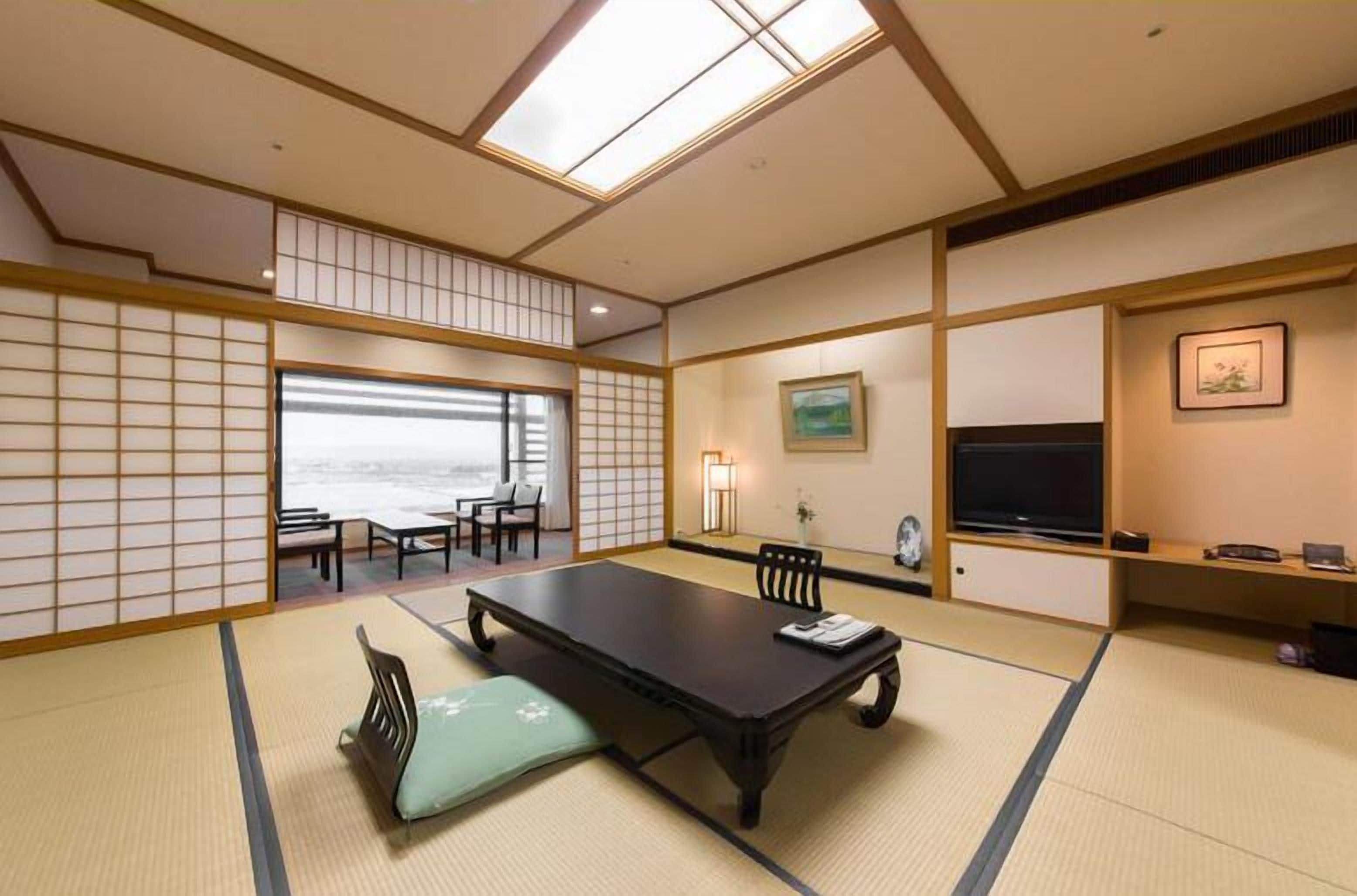 A traditional Japanese-style room with tatami flooring, a low table, and sliding doors.