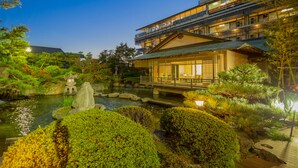 A traditional Japanese-style building with a koi pond and lush greenery. - Grandia Housen (Awara)