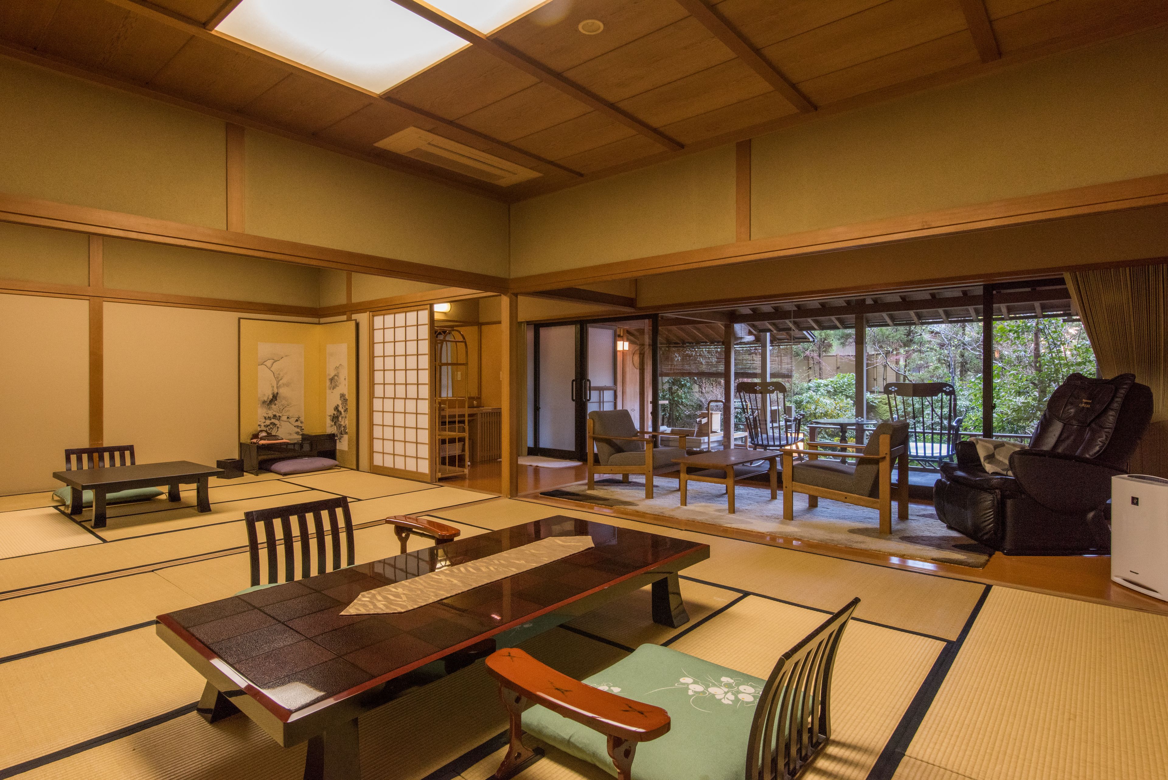Une pièce de style japonais traditionnel, avec un sol recouvert de tatamis, une table basse et des assises confortables.