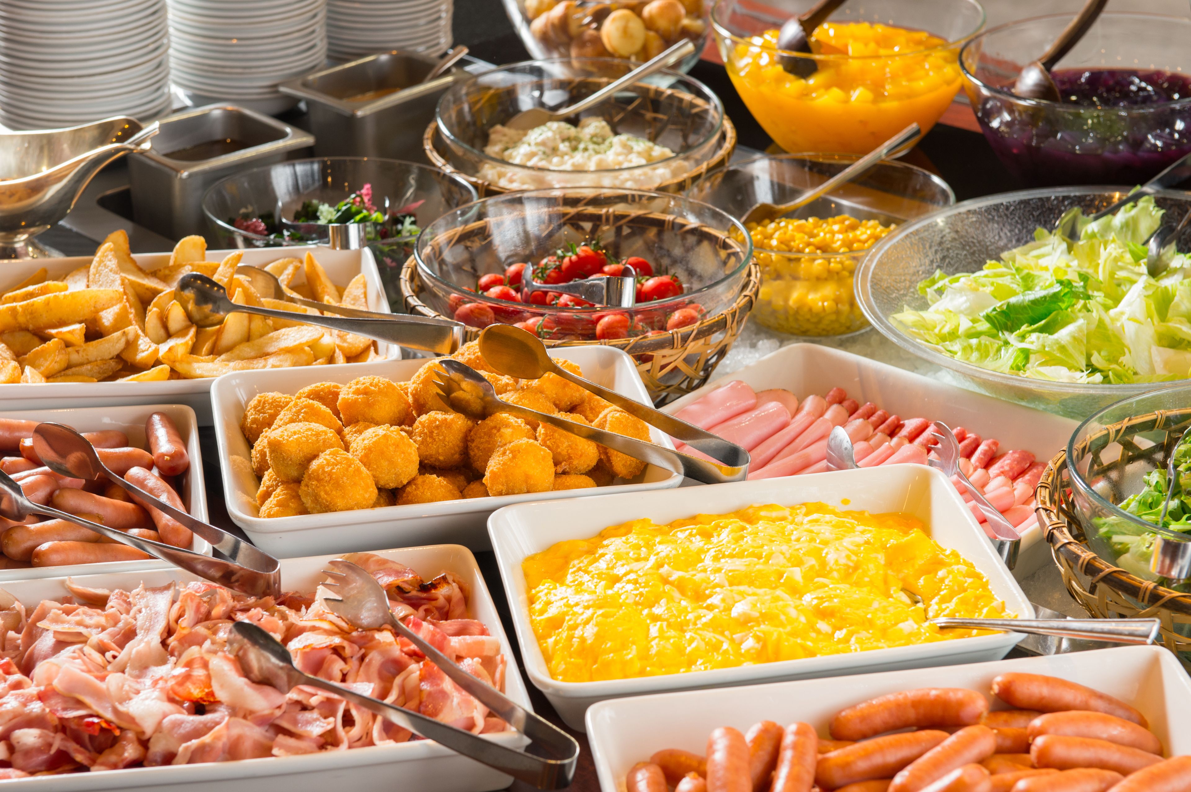 Ein reichhaltiges Buffet mit verschiedenen Speisen, darunter Fleisch, Käse und Salate.