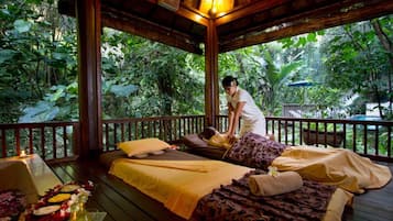 Relax on a serene deck surrounded by lush greenery, perfect for a rejuvenating massage.