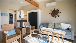 A living room with wicker furniture, a grey sofa, and a wooden coffee table.