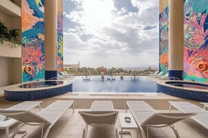 Una piscina al aire libre, sillones reclinables de piscina