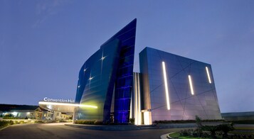 Un edificio moderno con fachada de vidrio y un cartel que dice "Convention Hall".