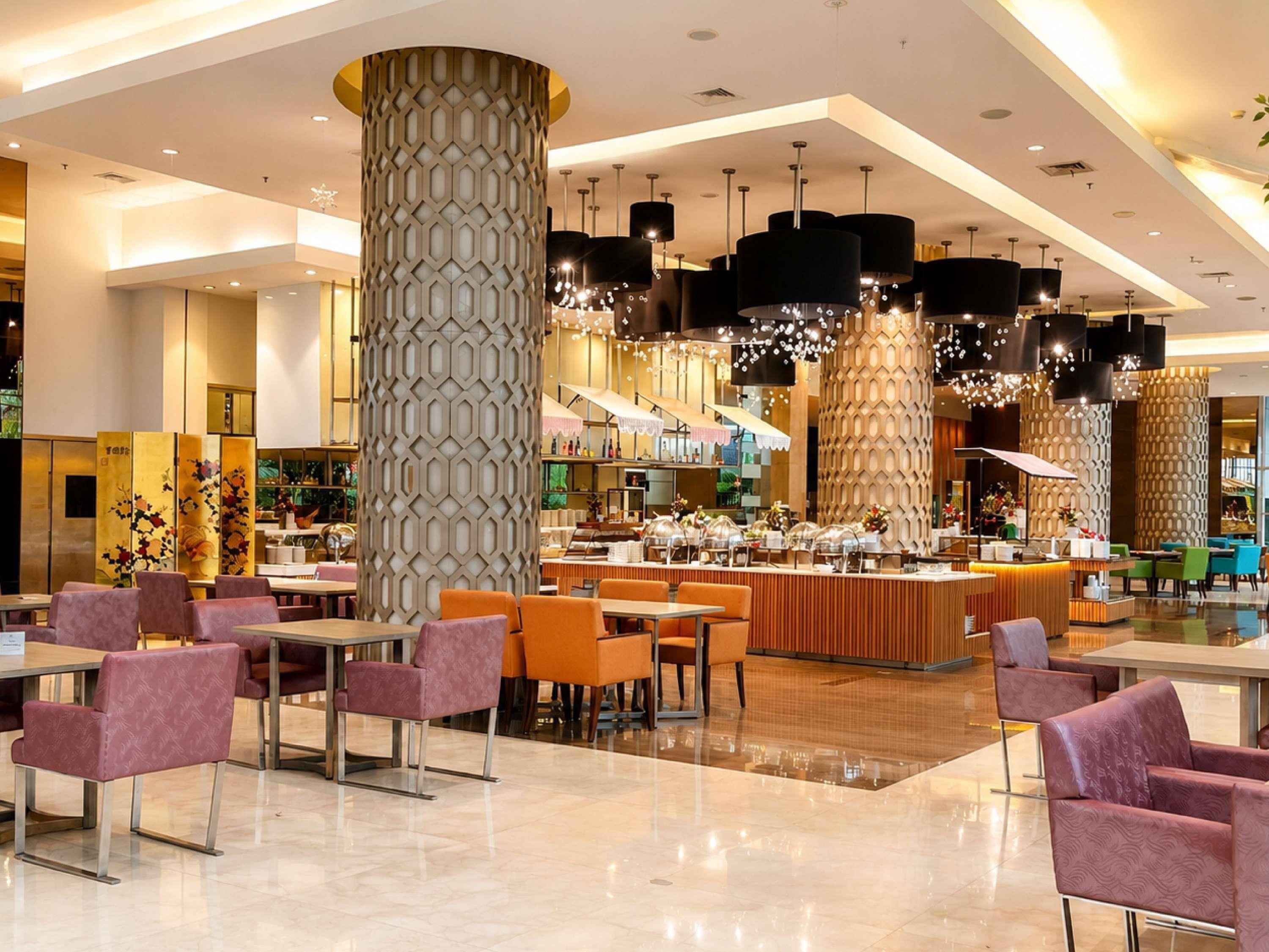 Un restaurante moderno con techos altos, iluminación colgante y una zona de bar central.