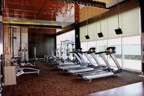 A gym with treadmills, elliptical machines, and weight equipment.