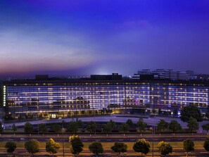 A modern building with a grid-like facade and multiple illuminated windows. - Novotel Nanjing East Suning (Nanjing)