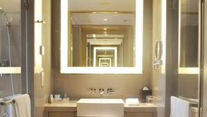 Een moderne badkamer met een grote spiegel, een wastafel en een douche.