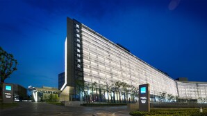 Een modern hotel met een opvallend verticaal bord en een gebogen gevel.