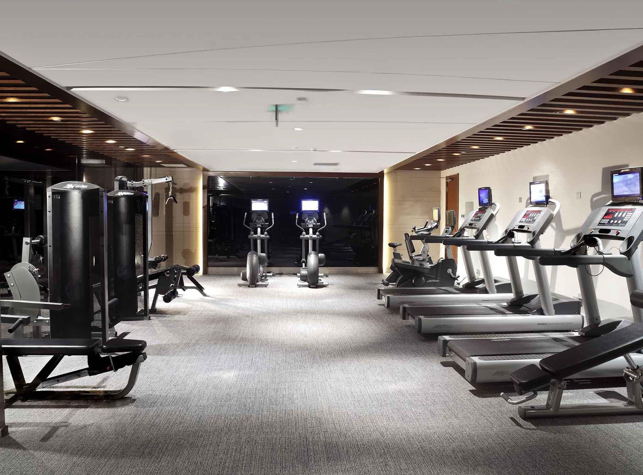 A gym with treadmills, elliptical machines, and weightlifting equipment.