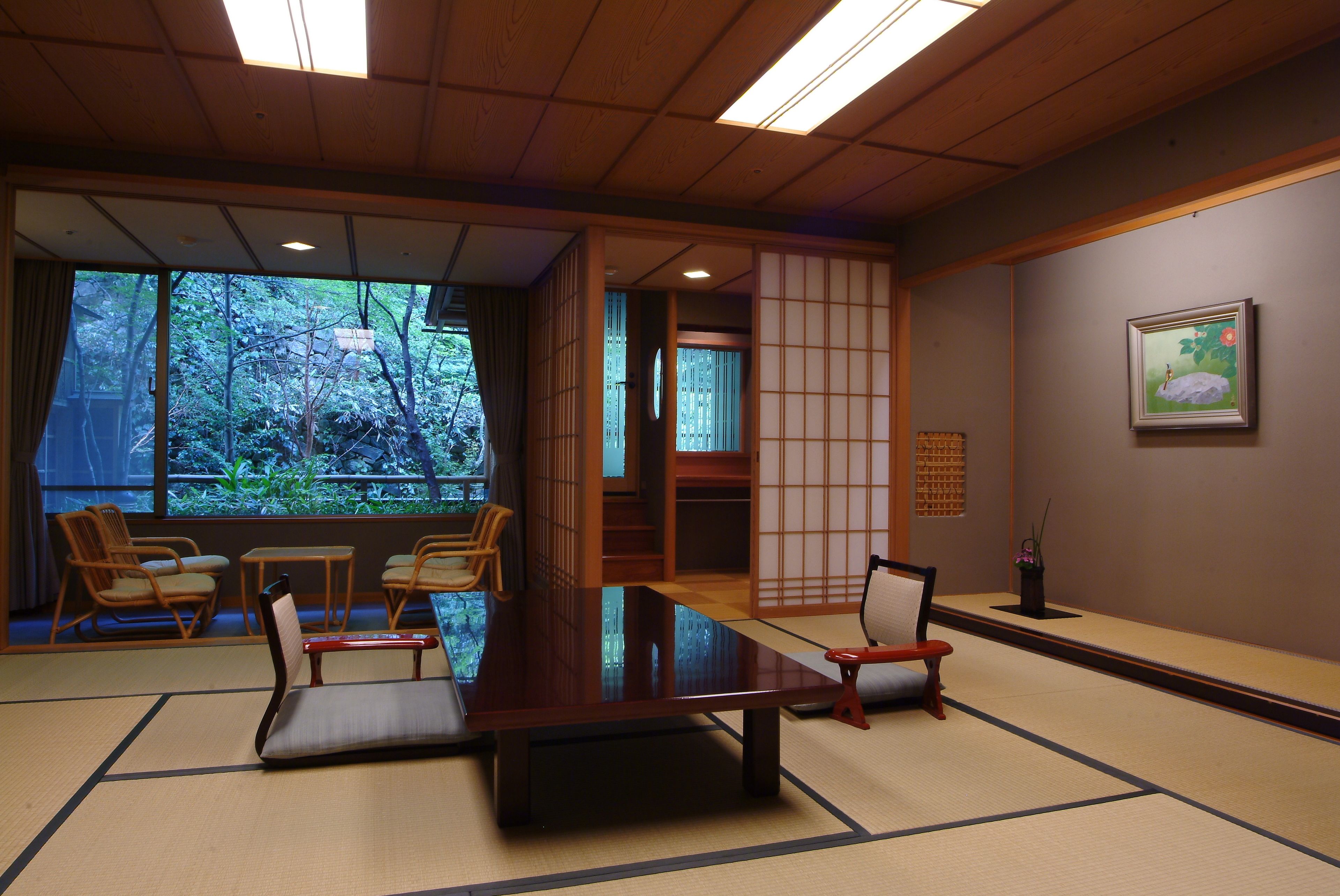 A traditional Japanese room with tatami flooring, a low table, and shoji screens.