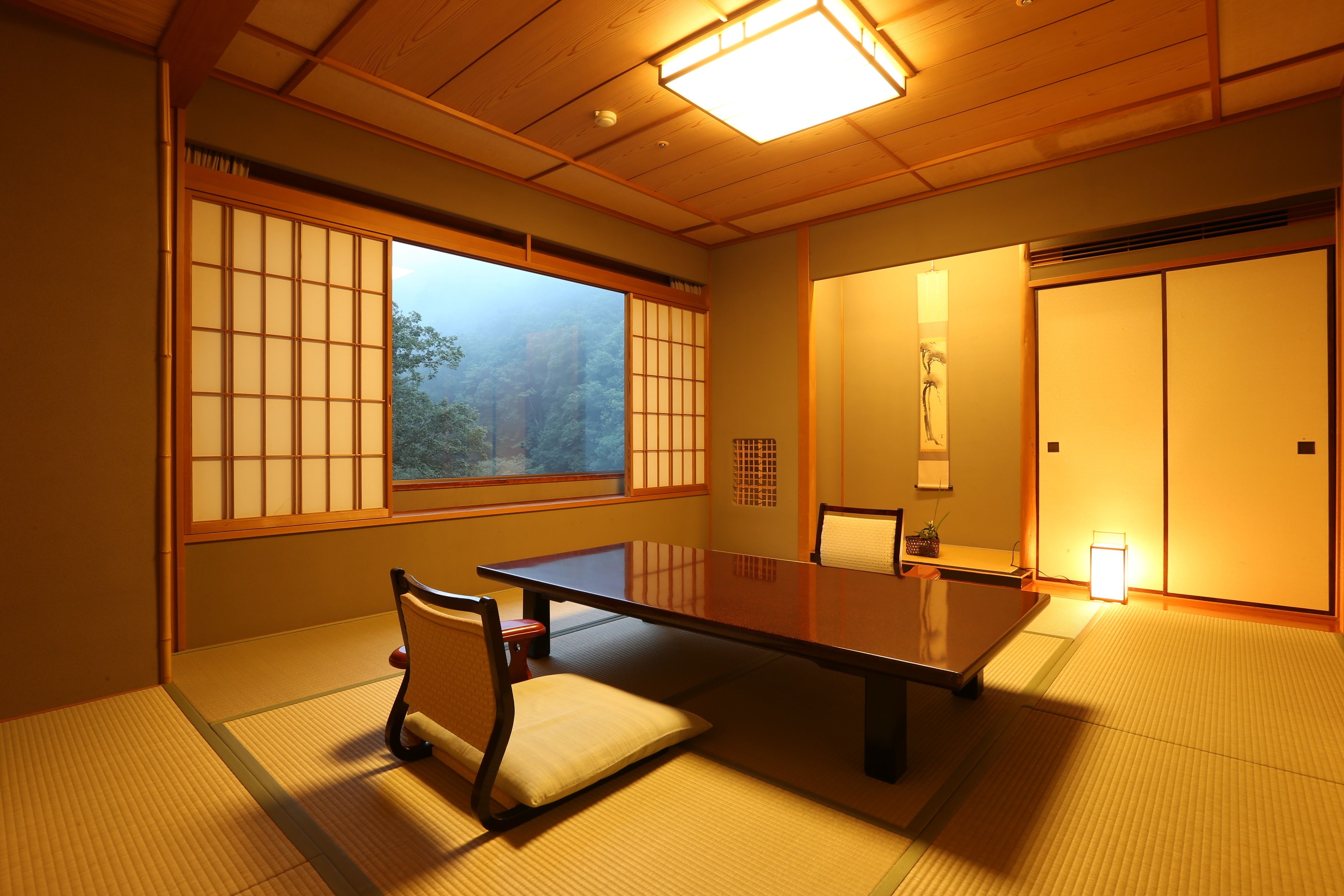 Ein traditioneller japanischer Raum mit Tatami-Böden, einem niedrigen Tisch und Schiebetüren.