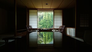 Een traditionele Japanse kamer met tatami vloeren, een lage tafel en twee tatami matten met kussens.