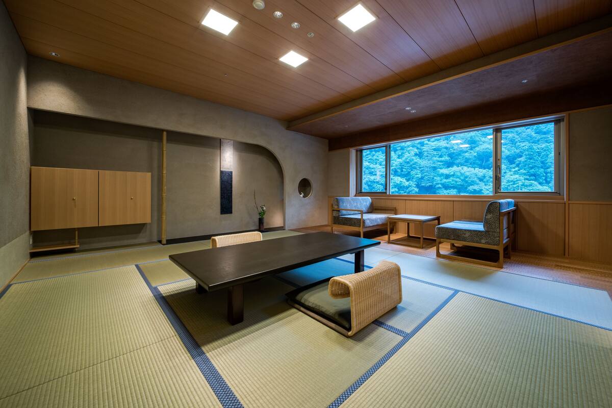Een traditionele Japanse kamer met tatami vloerbedekking, een lage tafel en zitplaatsen.
