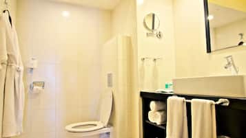 A bathroom with a toilet, a sink, a mirror, and a towel rack.