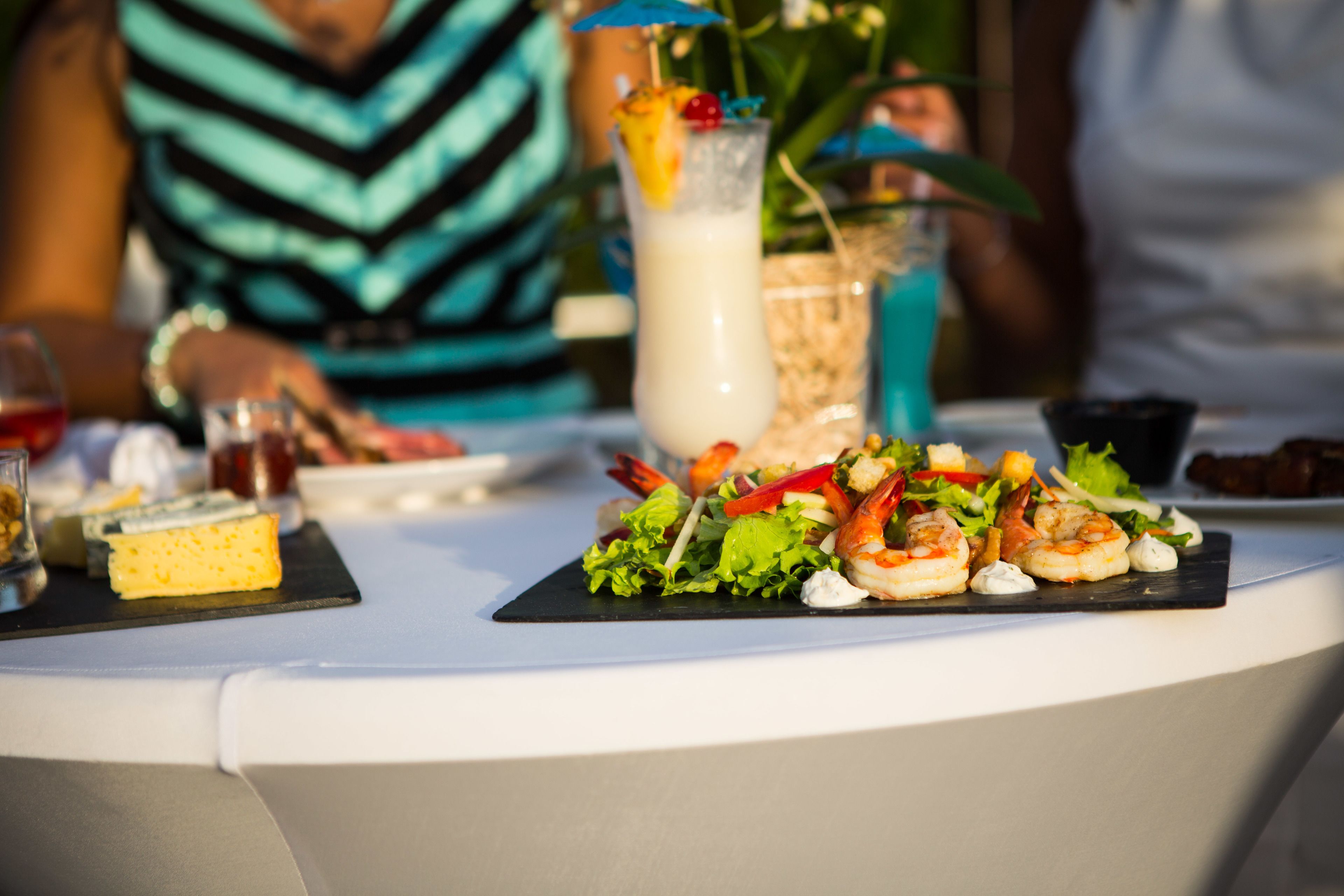 Ein Tisch mit Meeresfrüchte-Vorspeise, einem Getränk und einem Dessert.