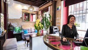 Un área de recepción con un mostrador, computadora y un acuario grande.