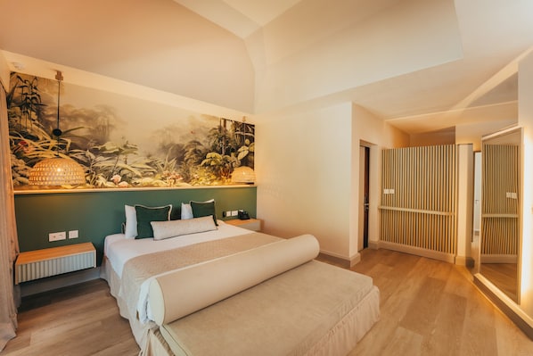 Een slaapkamer met een bed, nachtkastjes, een bankje, een wandlamp en een groot muurdecoratie.