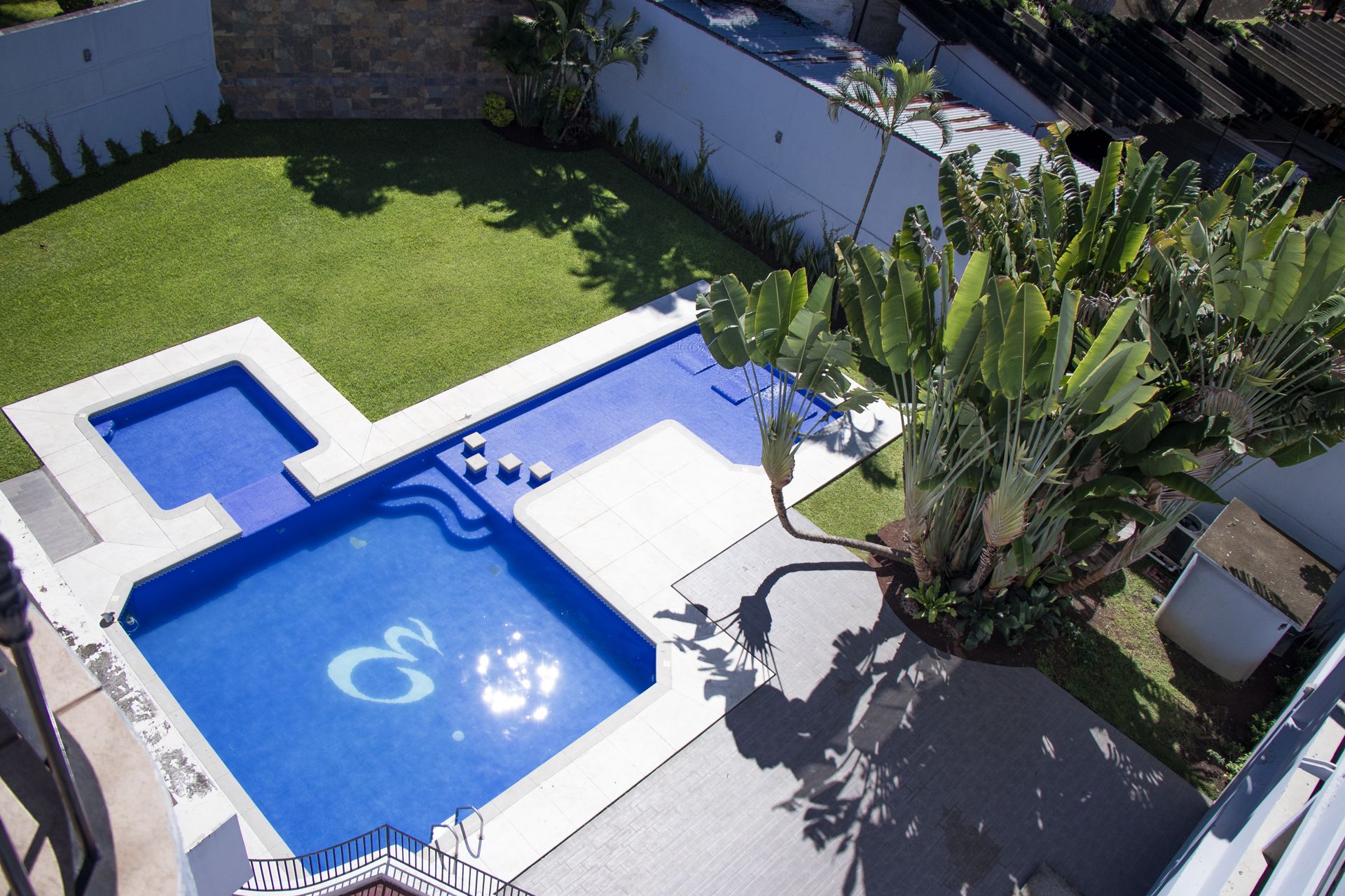 Alberca al aire libre y camastros 