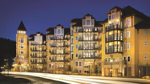 A multi-story hotel with balconies, a tower-like structure, and a well-lit facade. - The Ritz-Carlton Club, Vail (Vail)