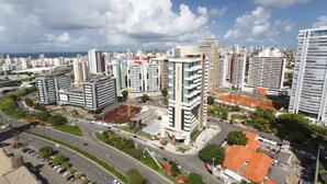 A cityscape with modern high-rise buildings, a curved road, and a clear sky.