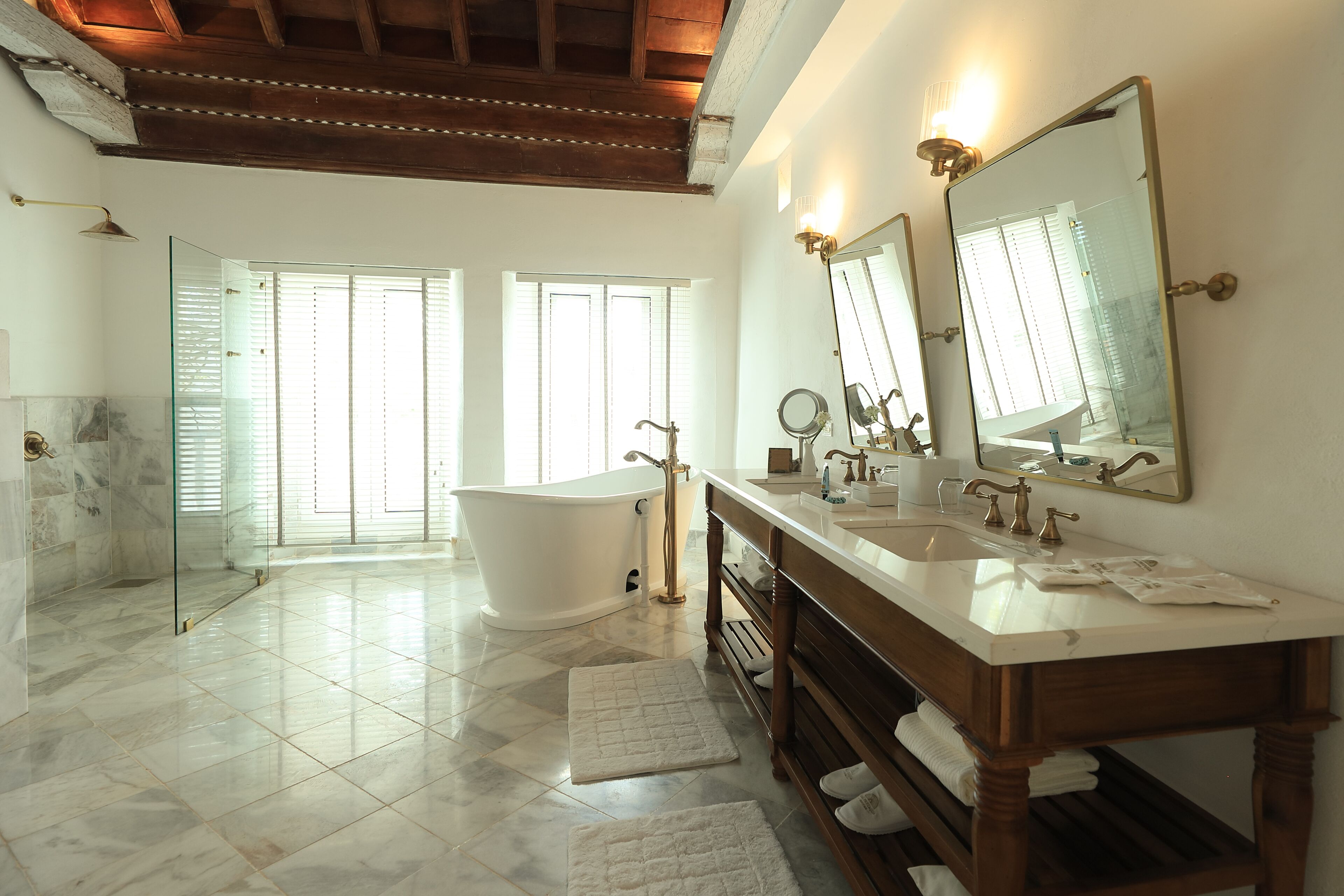 Une salle de bain spacieuse avec une baignoire îlot, un meuble-lavabo à deux vasques et un grand miroir.