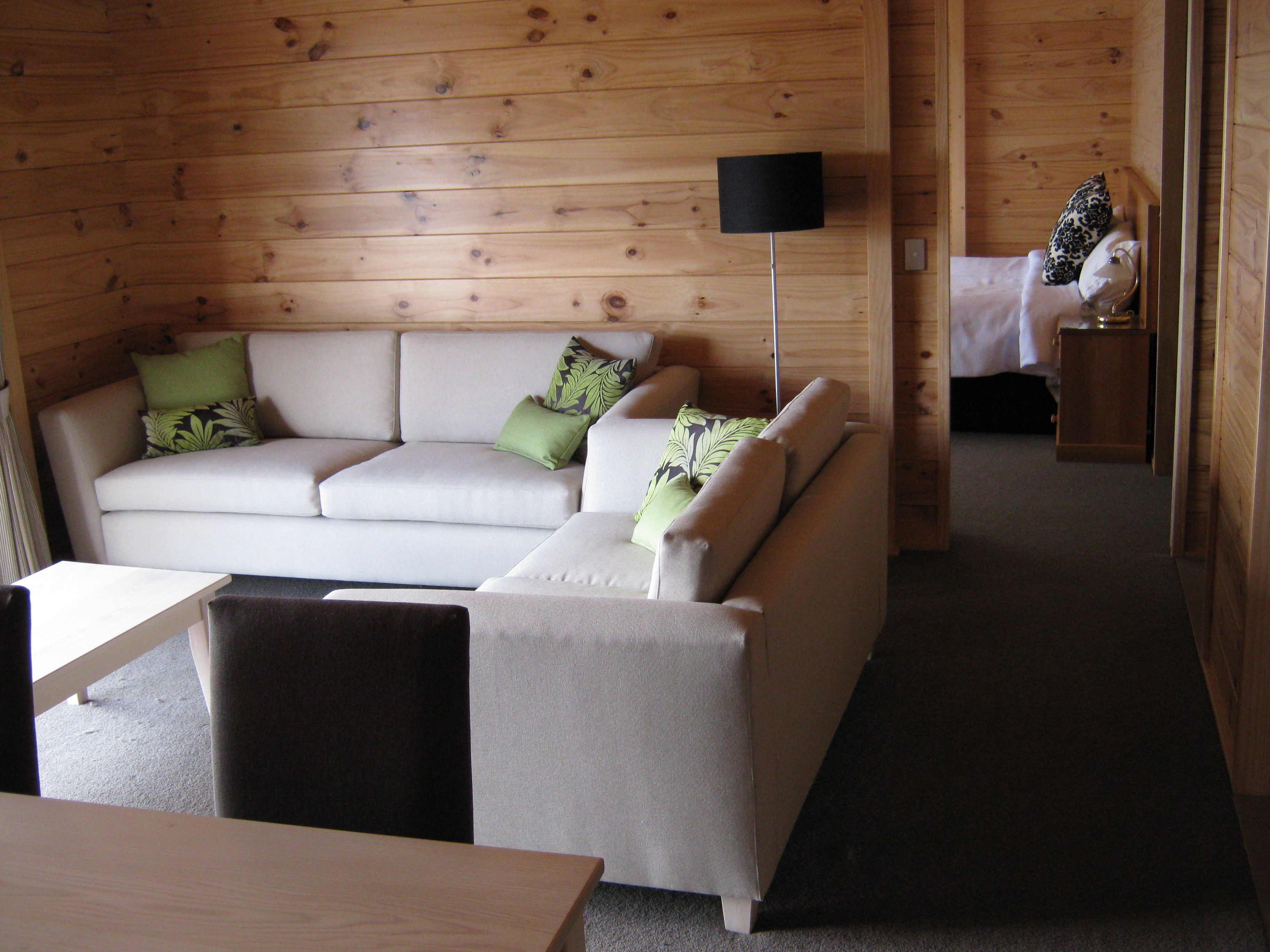 A cozy room with a sofa, a small table, and a bed with a nightstand.