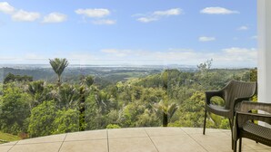 A balcony with a view of a lush landscape, including trees and distant hills. - Waitakere Resort & Spa (Auckland)