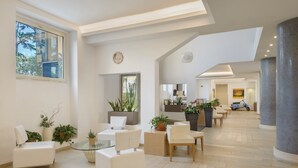 A spacious living area with modern furniture, large windows, and potted plants. - Occidental Aurelia (Rome)