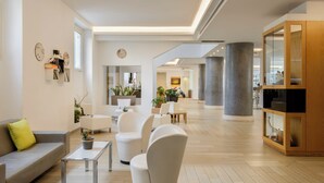 A modern interior with a sofa, armchairs, a coffee table, and a cabinet. - Occidental Aurelia (Rome)