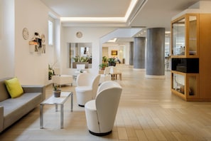 A modern interior with a sofa, armchairs, a coffee table, and a cabinet. - Occidental Aurelia (Rome)