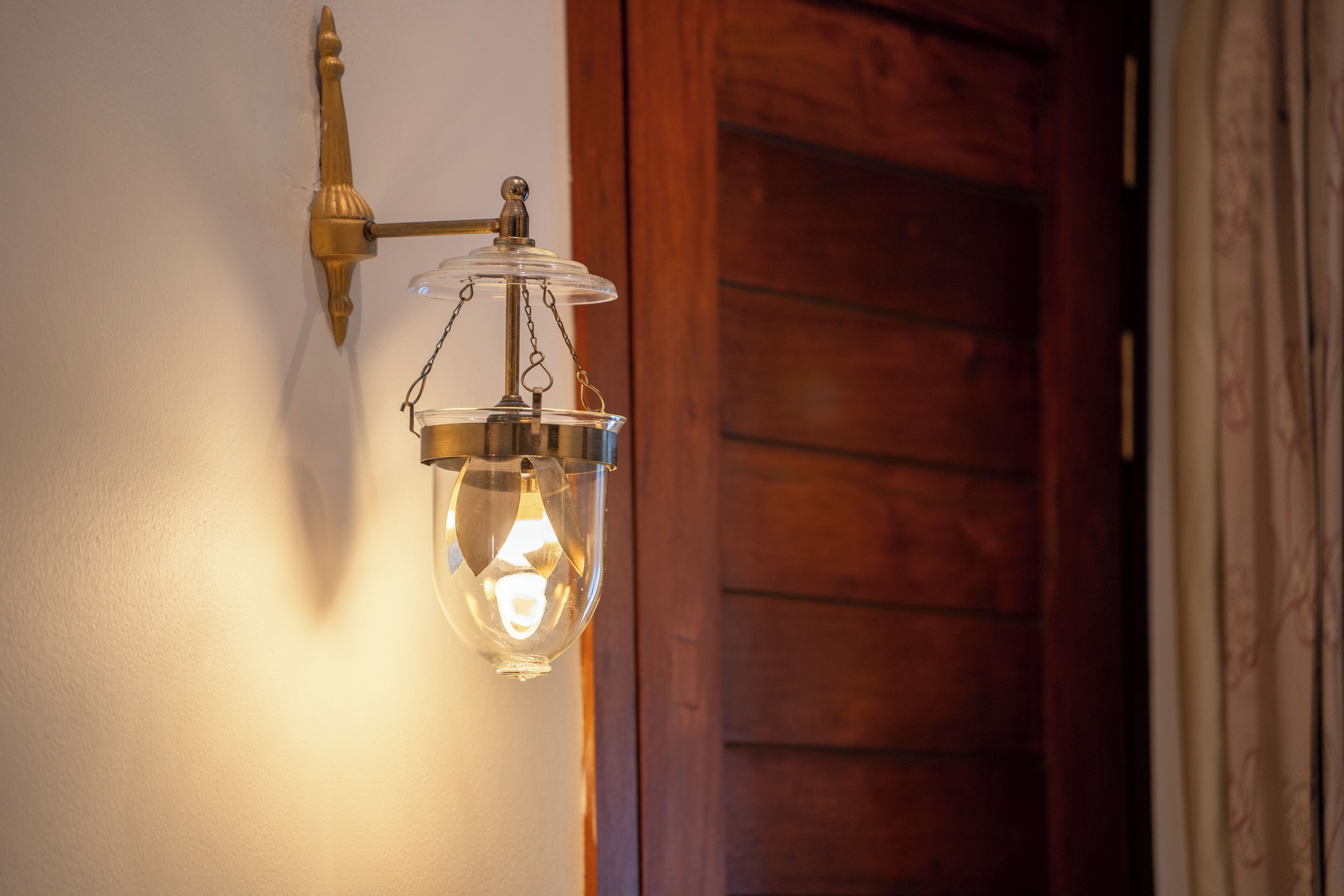 A wall-mounted light fixture with a clear glass shade and a metal base.