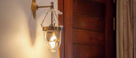 A wall-mounted light fixture with a clear glass shade and a metal base.