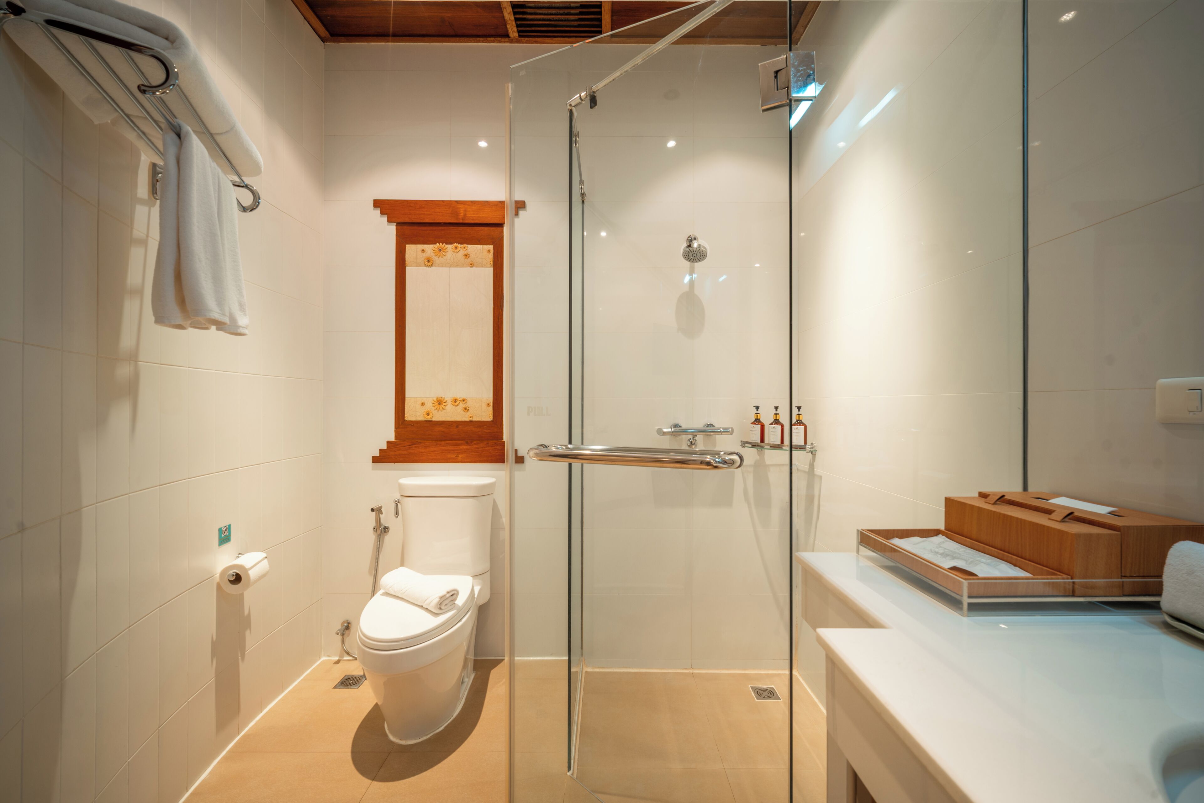 A modern bathroom with a glass shower enclosure, a toilet, and a vanity with a mirror.