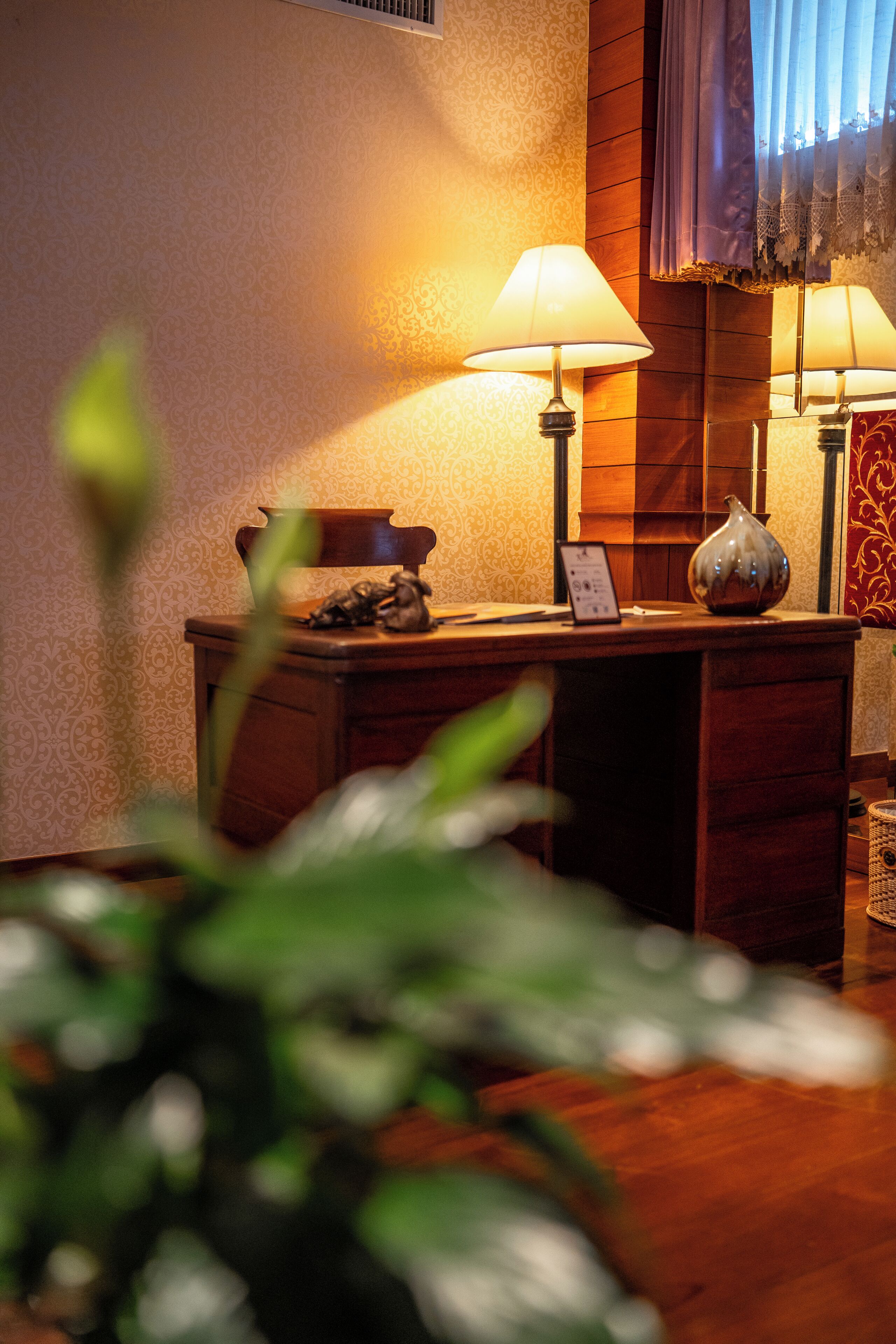 Ein Holztisch mit zwei Lampen, einer Vase und einem kleinen Tisch mit einem Schild.