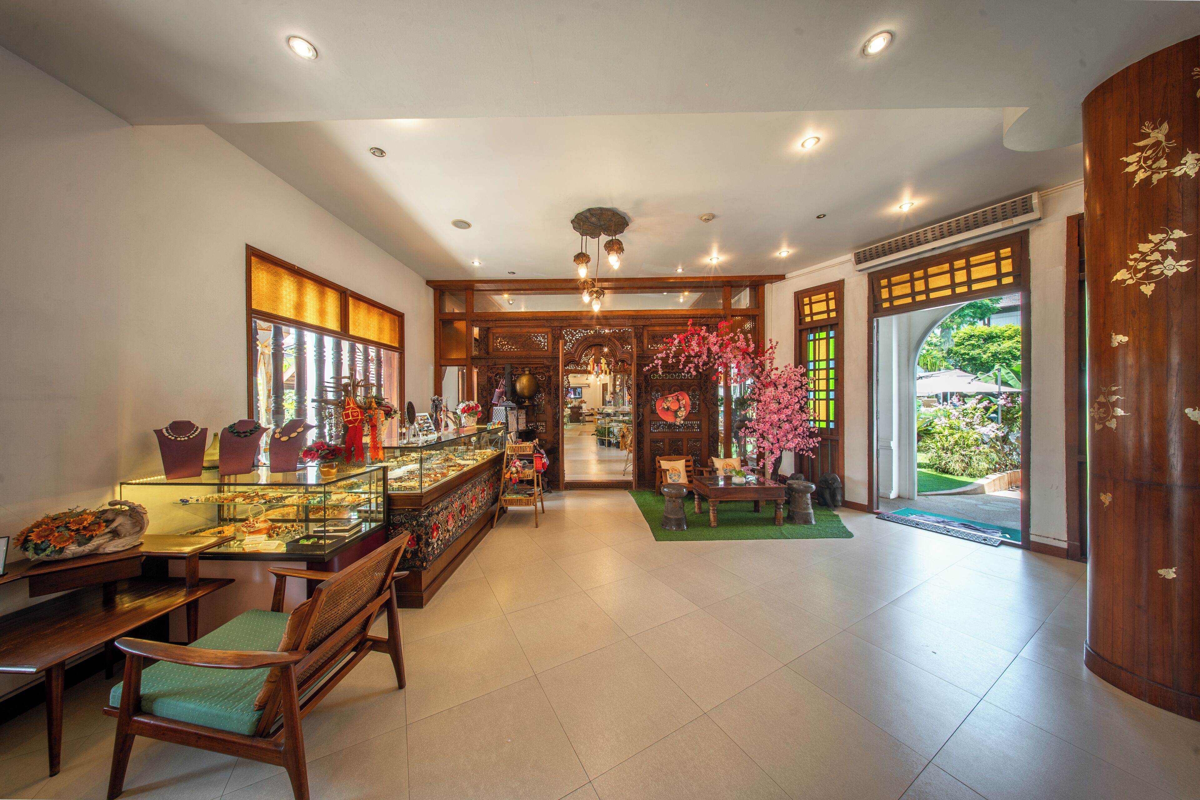 A traditional interior with wooden furniture, a display case, and a view through a doorway.