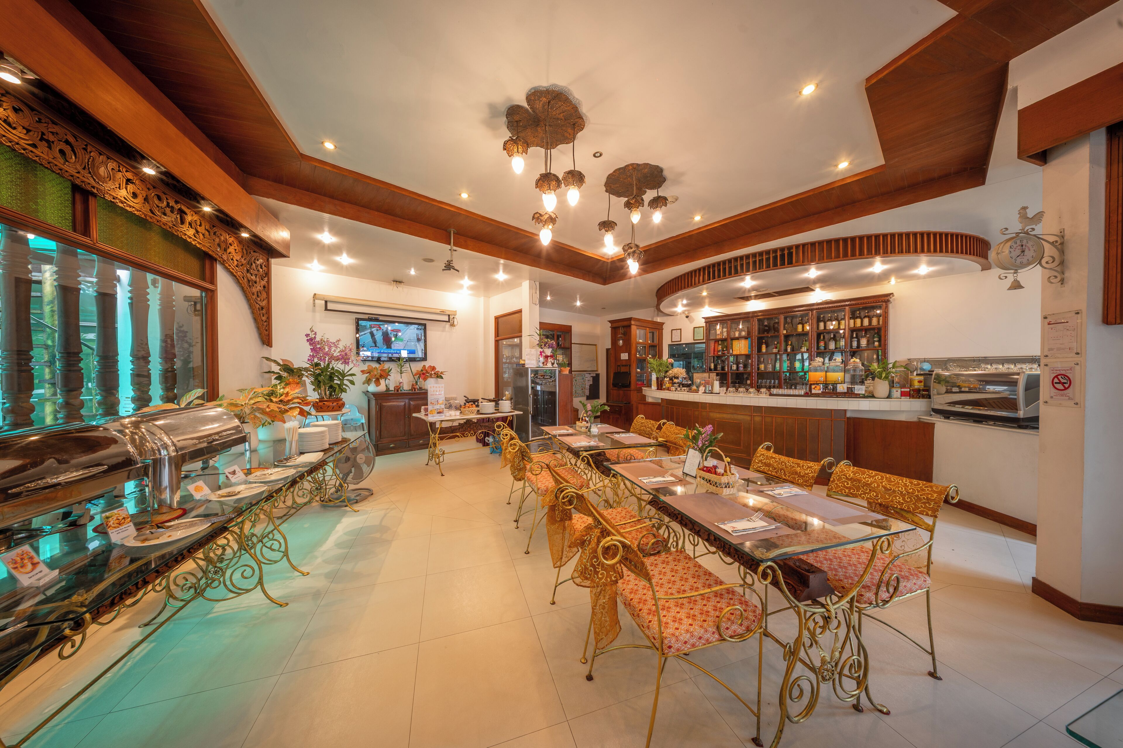 Un vaste espace dédié à la salle à manger, avec une longue table de buffet, des chaises élégantes et un bar proposant une grande variété de boissons.