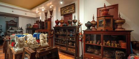 Une pièce meublée de meubles en bois, avec une grande armoire aux portes vitrées et un tableau encadré accroché au mur.